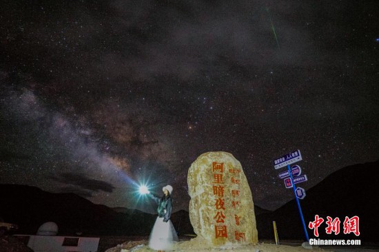 圖為6月20日晚，游客“打卡”西藏阿里暗夜公園，天上是銀河與流星（右上角）。曹枝清 攝